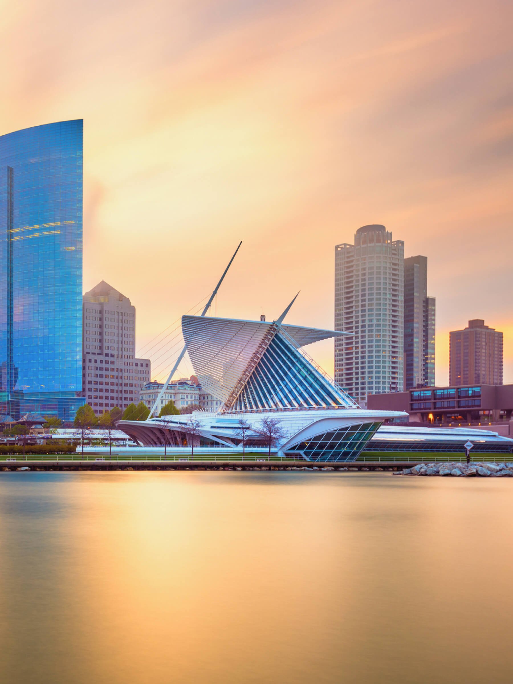 Sunset over the skyline of downtown Detroit, Michigan, featuring the modern building known as the Quadracci Pavilion of the Detroit Institute of Arts.