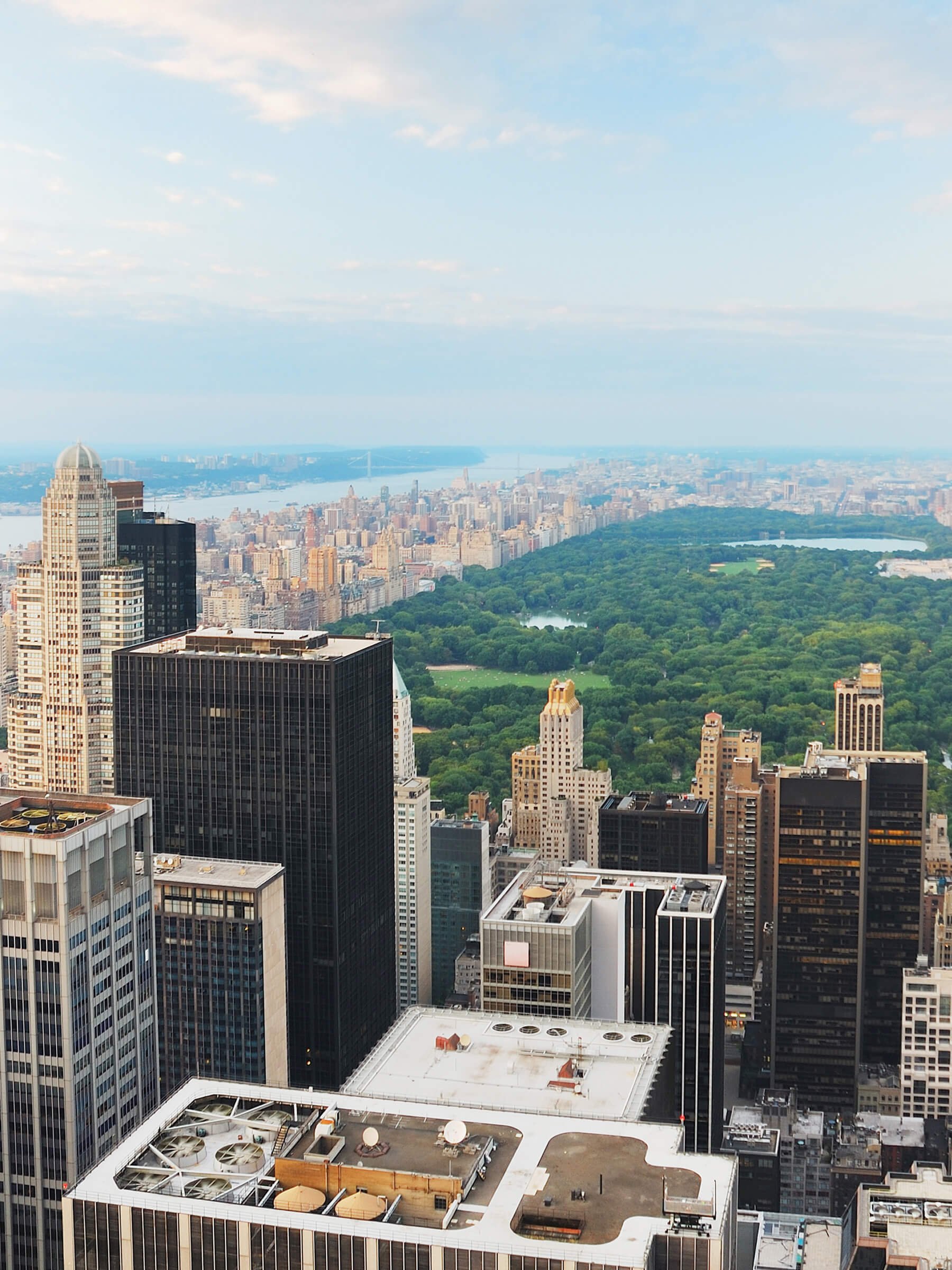 A high-angle view of New York City skyline with tall skyscrapers and Central Park in the background.